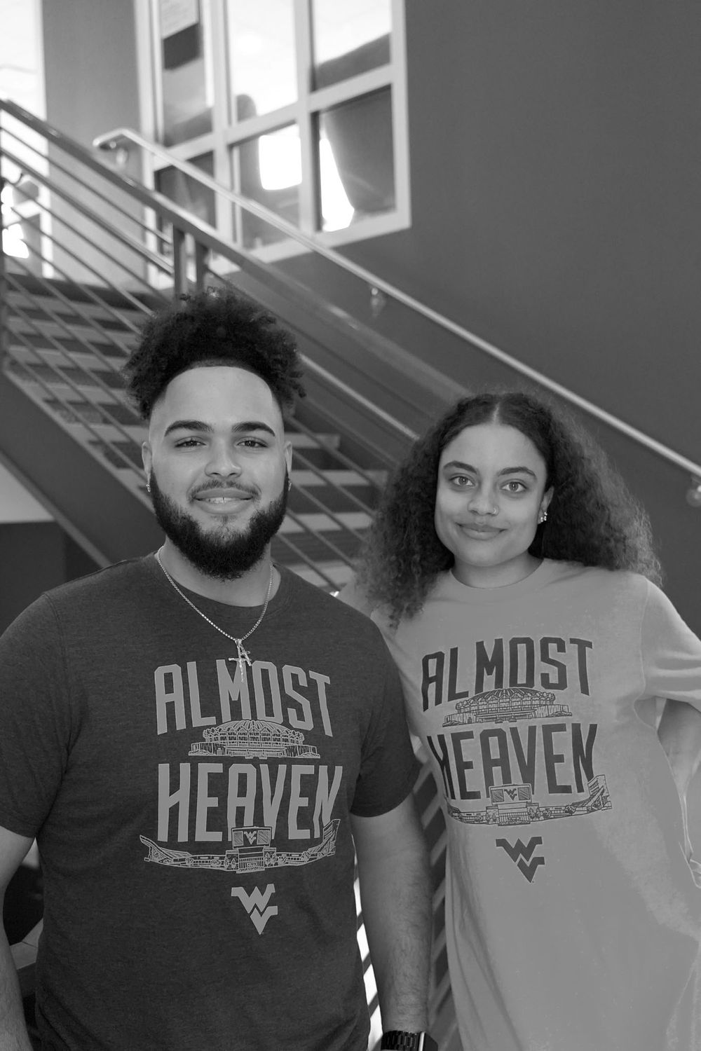 black and white photo of Male and female students on staircase in WVU shirts